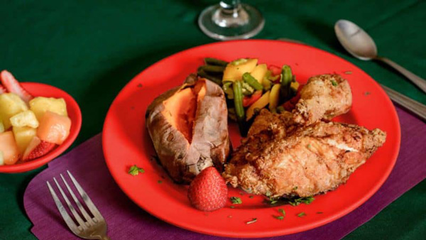 Fried chicken dinner with backed sweet potatoe, mixed vegetables and mixed fruit cup