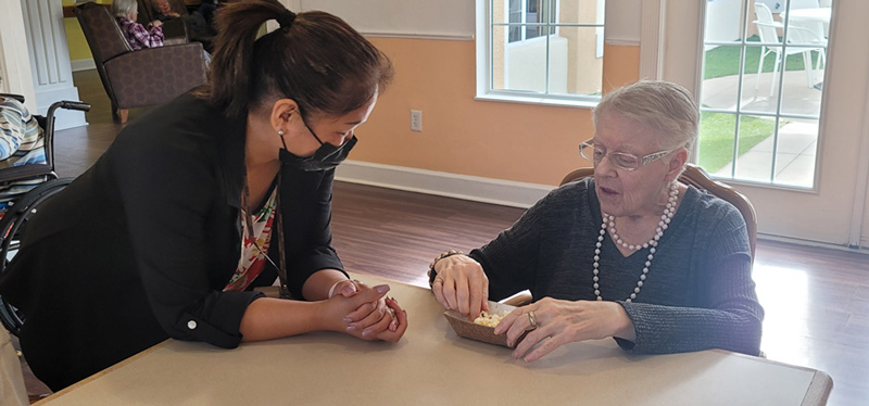 Resident talking with staff while enjoying some popcorn